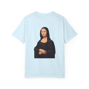 The back of a light blue t-shirt features a graphic of the Mona Lisa portrait.