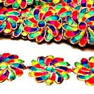 May include: A decorative trim featuring a repeating pattern of vibrant, multi-colored flower shapes. Each flower consists of individual petals in shades of red, yellow, green, blue, and purple, outlined with a metallic gold-toned thread border.