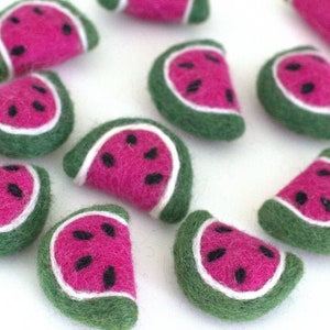 May include: A collection of felt watermelon slices in various shades of pink, green, and white. Each slice has a white outline and black seeds.