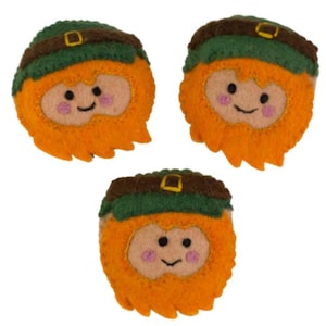May include: Three felt leprechaun faces with orange beards, rosy cheeks, and smiling faces. Each leprechaun has a green hat with a brown brim. The background is plain white.