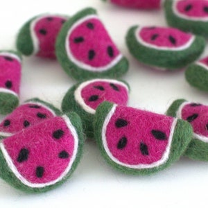 May include: A collection of felt watermelon slices in various shades of green, pink, and white. The watermelon slices are hand-crafted and have a realistic appearance.