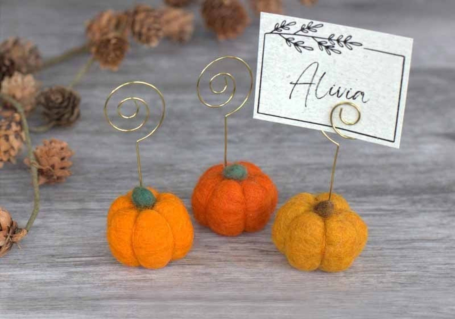 A Pumpkin Holder with a Wire Name Loop Small pumpkin-shaped place card holders with upright wire loops.