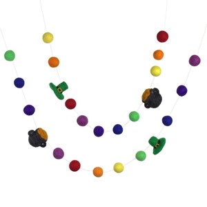 May include: A rainbow felt ball garland with green shamrock hats, a pot of gold, and a leprechaun. The garland is strung on white thread and is perfect for St. Patrick's Day decorations.