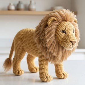 May include: A handcrafted crochet lion toy featuring a golden-yellow yarn body with a textured stitch pattern. The lion has a full, shaggy mane made of light brown yarn, dark brown embroidered eyes, a brown nose, and a long tail with a tufted end.