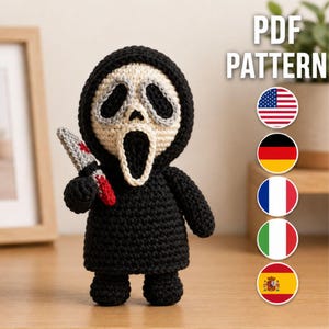 May include: A crochet doll featuring a black hooded robe and a white mask with large black eye and mouth openings. The doll holds a small grey knife with red accents. The text PDF PATTERN is visible, along with five circular national flag icons.
