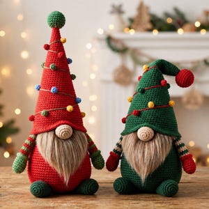 Peut inclure: Deux gnomes en crochet avec de longues barbes en fausse fourrure et des nez ronds. Le plus grand gnome a un chapeau pointu rouge avec de petits pompons colorés et des manches rayées vertes. Le plus petit a un chapeau vert avec des pompons rouges.
