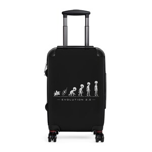 May include: Black rolling suitcase with a silver handle and wheels. The suitcase features a white graphic of alien evolution with the text "EVOLUTION 2.0" below the graphic. The suitcase has red accents on the wheels.