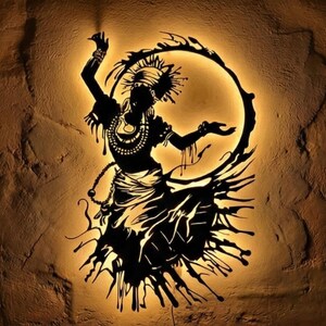 May include: Black silhouette of a dancing figure with a halo-like ring, illuminated against a warm, textured background. The figure is adorned with jewelry and a headdress, with flowing skirt details. The artwork evokes a sense of movement and cultural expression.