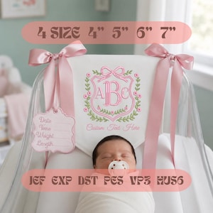 May include: A white fabric banner featuring an embroidered pink monogram crest with a bow and floral wreath. The banner includes a pink satin ribbon, a matching tag with lines for birth details, and text reading 4 SIZE 4" 5" 6" 7" and JEF EXP DST PES VP3 HUS6.