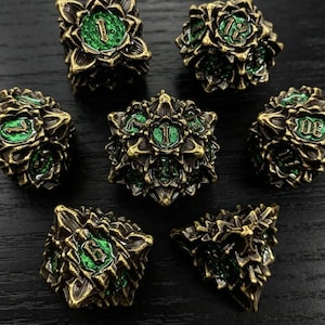 May include: Set of seven ornate, bronze-colored polyhedral dice with green accents. Each die features a unique number in a stylized font. The dice have a detailed, textured surface, suitable for tabletop gaming.