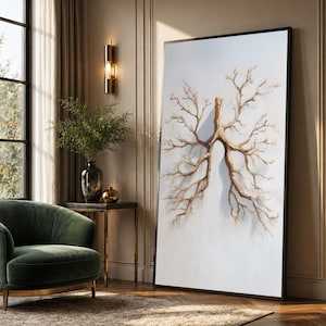 May include: A large rectangular wall art piece featuring a white textured background with a central brown, branch-like structure that resembles the shape of human lungs. The artwork is framed in a thin black border and stands upright on the floor.