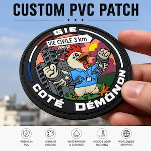 May include: A circular PVC patch featuring a cartoon chicken in a blue shirt with broken chains on its wrists. The background shows a city and a sign reading GIE VIE CIVILE 3 km. The text COTÉ DÉMONON is printed in white along the black border.