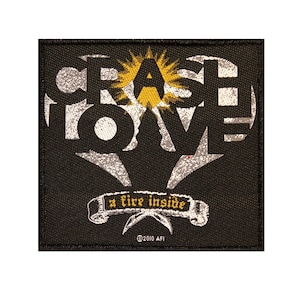 May include: Black and white embroidered patch with the words "Crash Love" in a heart shape with a yellow sunburst behind the "A". A banner below reads "a fire inside" with the copyright symbol and "2010 AFI".