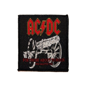 May include: Black embroidered patch with the band name "AC/DC" in red and yellow lettering. The patch features a silver cannon with the text "For those about to rock, we salute you".