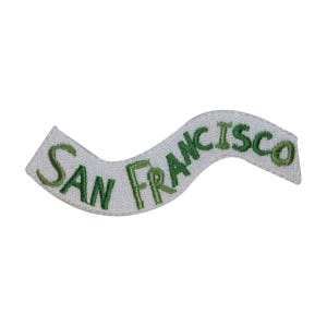 May include: White embroidered patch with the text "SAN FRANCISCO" in green lettering on a curved white background.