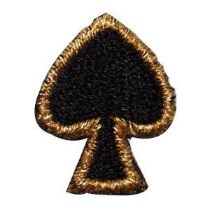 May include: A black felt spade playing card with a gold embroidered border.