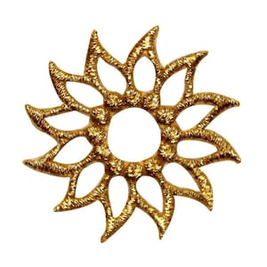 May include: A gold-colored metal sunburst design with a circular center and 12 points. The sunburst is intricately detailed with a textured surface.