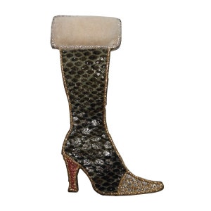 May include: A green and gold boot with a white fur cuff. The boot has a high heel and a pointed toe.