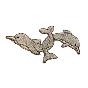 May include: Two embroidered gray dolphins leaping out of the water. The dolphins are facing opposite directions and are stitched with brown thread.