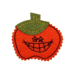 May include: A felt orange pumpkin with a green felt stem and a stitched-on smiling face with star-shaped eyes.