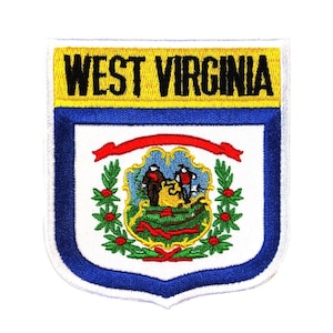 May include: An embroidered patch featuring the state seal of West Virginia. The seal depicts two men standing on a mountain with a river flowing below. The seal is surrounded by a wreath of green leaves and red berries. The patch is blue, white, red, green, and yellow.
