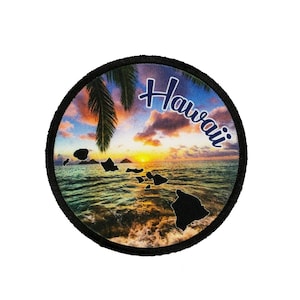 May include: A round, black-edged patch with a colorful sunset over the ocean. The silhouette of the Hawaiian islands is visible in the water. The word "Hawaii" is written in a blue cursive font across the top of the image.