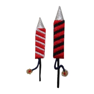 Può includere: Due petardi rossi e bianchi a strisce con punte argentate e uno spago nero. I petardi sono su uno sfondo bianco.