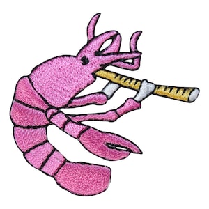 May include: Embroidered patch featuring a pink shrimp playing a flute. The shrimp has black details and is set against a white background. The flute is yellow with black accents. This whimsical patch is perfect for adding a unique touch to clothing or accessories.
