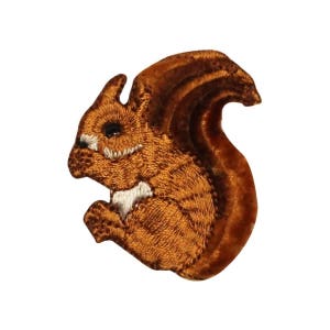 May include: A brown embroidered squirrel patch with white accents. The squirrel is sitting up with its tail curled around its body.