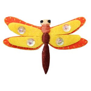 Peut inclure: Une libellule en feutre jaune avec des bordures rouges et des paillettes irisées. La libellule a un corps brun et est un élément décoratif.