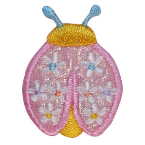 Può includere: Coccinella ricamata rosa con accenti gialli e fiori bianchi. La coccinella ha antenne blu.