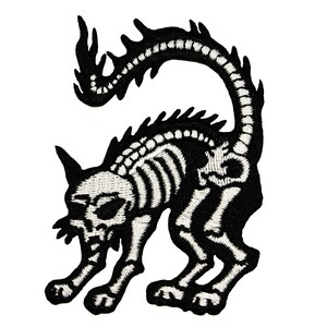 Può includere: Toppa ricamata in bianco e nero di un gatto scheletro con la coda arrotolata. Il gatto è in posizione accovacciata con la testa girata di lato.
