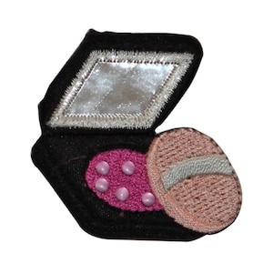 May include: A black fabric patch with a pink and beige makeup compact design. The compact has a mirror and a pink blush with five pink dots.