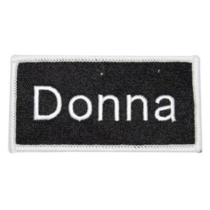 May include: Black rectangular fabric patch with white stitching around the edges. The word "Donna" is embroidered in white on the black fabric.