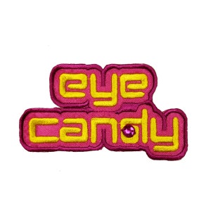 May include: A pink and yellow embroidered patch with the text "eye candy" and a pink rhinestone.