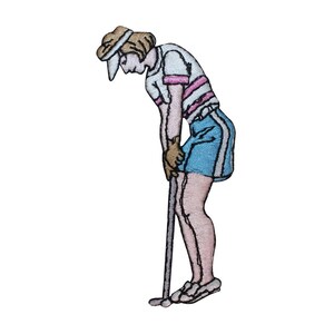 Könnte beinhalten: Ein gestickter Aufnäher einer Golferin, die ein weißes Shirt mit rosa Streifen, einen blauen Rock mit weißen Streifen und einen braunen Hut trägt. Sie hält einen Golfschläger und befindet sich in einer Putting-Position.