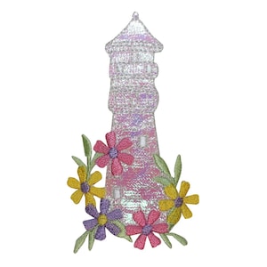 May include: A white and pink iridescent lighthouse with a white roof and windows. The lighthouse is surrounded by pink, yellow, and purple flowers with green leaves.