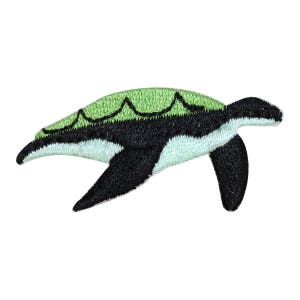 May include: An embroidered patch of a green and black sea turtle with a white underbelly.