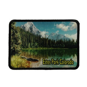 May include: A black and white embroidered patch with a scenic image of a lake and mountains. The text "Estes Park Colorado" is printed in yellow on the bottom of the patch.