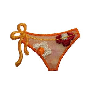 May include: Orange and white embroidered bikini bottom patch with a red heart design.