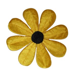 May include: A yellow felt flower with six petals and a black center. The flower is about 3 inches in diameter.
