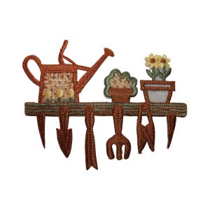 May include: An embroidered patch depicting a gardening scene with a watering can, a flower pot, and gardening tools hanging on a wooden rack. The patch is brown, green, and yellow.