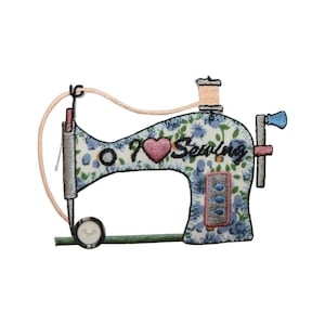 May include: Embroidered iron-on patch of a blue sewing machine with a floral pattern. The machine has a pink heart with the text "I Love Sewing" on it.