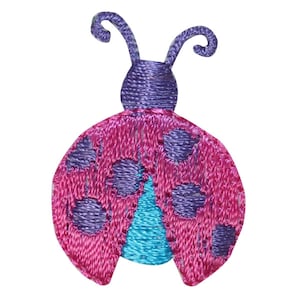 Peut inclure: Une coccinelle brodée rose et violette avec des ailes bleues et des points noirs.