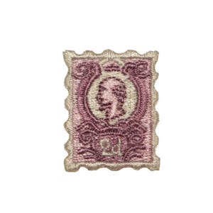 May include: A pink and white embroidered patch shaped like a postage stamp with a profile of a person in the center.