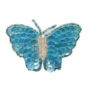 May include: A blue butterfly-shaped sequin applique with a white center. The sequins are iridescent and create a shimmering effect.