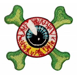 May include: A green and red embroidered patch with a skull and crossbones design. The skull is an eye with a black pupil, a white sclera, and a blue and yellow iris. The crossbones are green with a yellow outline.