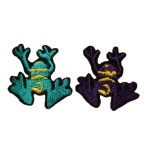 May include: Two embroidered frog patches, one teal and one purple, with yellow accents and the number 3.
