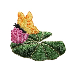 Peut inclure: Patch brodée thermocollante représentant un papillon jaune et orange perché sur un nénuphar vert avec une fleur rose.