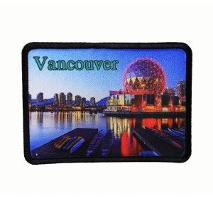 May include: A black and white embroidered patch with a colorful image of the Vancouver skyline at night. The image features the city's iconic Science World building, a large geodesic dome, with the text "Vancouver" in green letters.